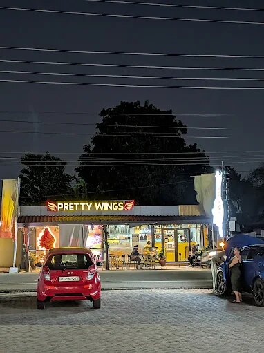Pretty Wings storefront glowing at night